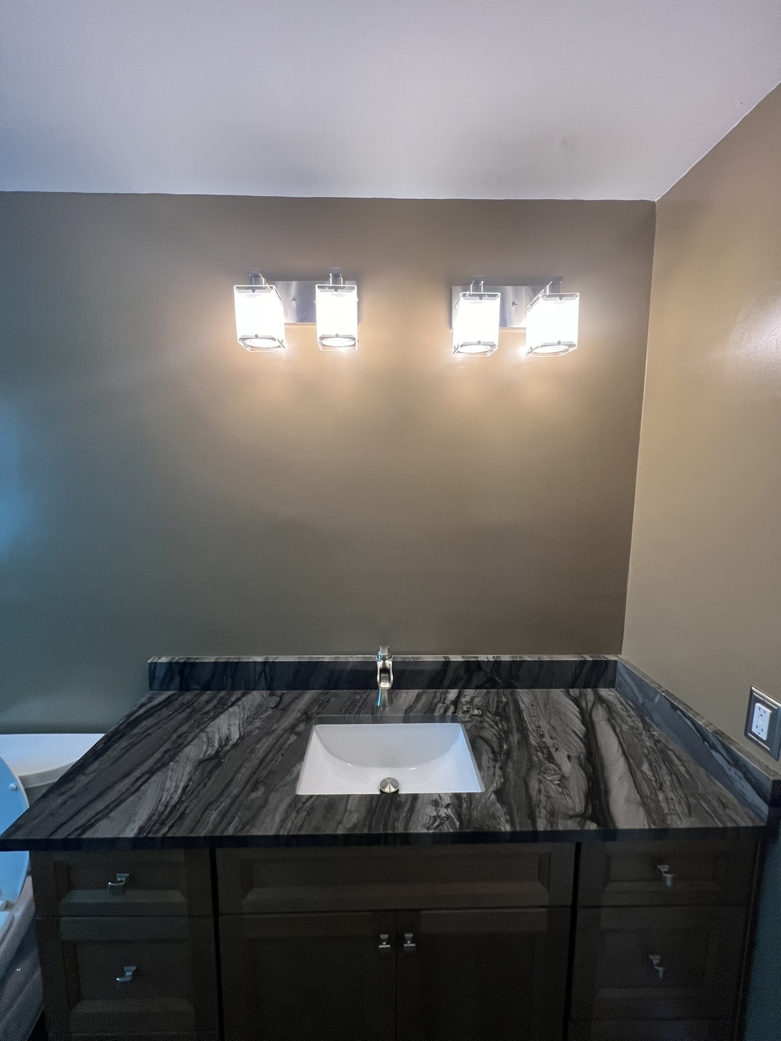 Vanity countertop features Level 5 polished granite