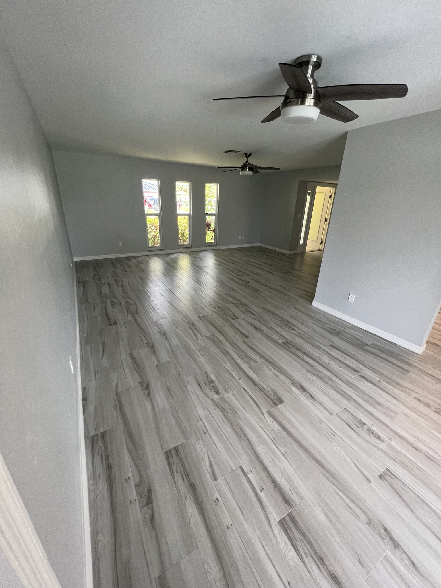 New wood-look ceramic tiles were laid with random joints and minimal grout lines, achieving a natural, seamless look